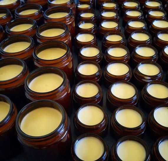 Overhead view of Mirath Beauty amber glass jars filled with handcrafted tallow skincare, displayed on a dark background — representing Lebanese heritage, holistic beauty, and wholesale luxury.