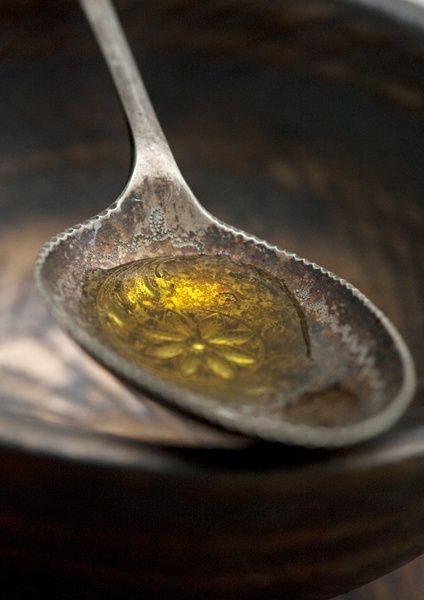 vintage metal spoon holding golden melted tallow, symbolizing tallow's vitamin rich profile - naturally abundant in vitamins A, D, E, and K for radiant, healthy skin