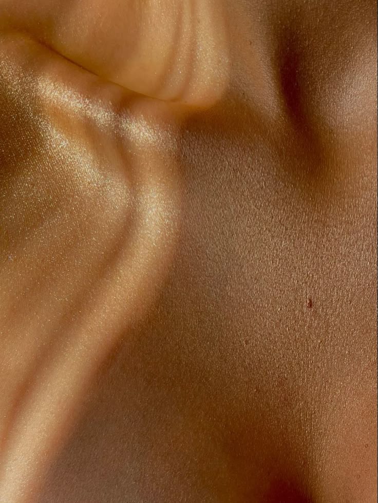 aesthetic, feminine close up of a woman's bronze-toned décolletage with visible skin texture, behind the about us quote on mirath's ancestral skincare philosophy